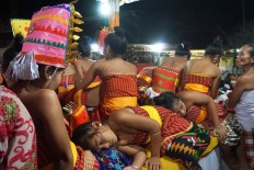 A Daha [young woman] sleeps while waiting for her turn to dance. The young participants are not allowed to eat, drink or carry their cell phones during the Usaba Dangsil ritual. JP/ Luh De Suriyani