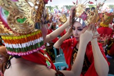 The dancers help each other get into costume before the performance. JP/Wendra Ajistyatama
