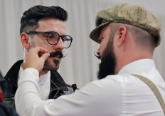 In this picture taken on Sunday, Oct. 16, 2016, a man performs final adjustments on another's mustache during the National Competition for Beards and Mustaches which took place along with the International Tattoo Convention Bucharest 2016 in Bucharest, Romania. More than 100 tattoo and piercing artists brought their skills and art to a three-day convention in the Romanian capital, while men showed off their facial hair in a contest.AP Photo/Vadim Ghirda
