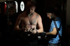 In this picture taken on Sunday, Oct. 16, 2016, a man gets a tattoo during the International Tattoo Convention Bucharest 2016 in Bucharest, Romania. AP Photo/Vadim Ghirda