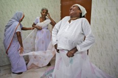 An Indian Hindu widow laughs as she wears a Sari backstage before participating in a fashion show fashion show in New Delhi, India, Saturday, Oct. 15, 2016. Until recently, Indian widows were expected to follow the sociocultural codes of a patriarchal Hindu society that demands a woman lead a life of asceticism after a husband’s death. Their lives appear to be changing for better with women's groups and Indian aid organizations taking interest in their welfare. AP Photo/Altaf Qadri