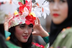 A dancer adjusts her flower crown before the tomato fight begins. JP/Arya Dipa