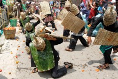 The participants, mostly vegetable farmers, start to throw tomatoes at each other before villagers and visitors can take part in the fight. JP/Arya Dipa
