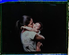 In this Sept. 26, 2016 photo made from a negative recovered from instant film, Angelica Pereira kisses her daughter Luiza, who was born with microcephaly, one of many serious medical problems that can be caused by congenital Zika syndrome, during a portrait session in Santa Cruz do Capibaribe, Pernambuco state, Brazil. "We are always chasing something. We have to drop everything else, all our chores, our homes," said the 21-year-old. "There are so many of us with children with special needs. [The government] is forgetting about that." AP Photo/Felipe Dana