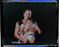 In this Sept. 29, 2016 photo made from a negative recovered from instant film, Vanessa dos Santos poses with her son, Enzo, who was born with microcephaly, one of many serious medical problems that can be caused by congenital Zika syndrome, in Recife, Pernambuco state, Brazil. Santos is one of the few mothers who lives within walking distance of a rehabilitation center. Enzo is eating well and gaining weight, but he has to take medication twice a day to control convulsions and still has difficulties with movements, especially in his hands. AP Photo/Felipe Dana
