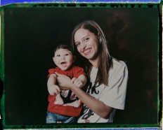 In this Sept. 29, 2016 photo made from a negative recovered from instant film, Daniele Ferreira dos Santos holds her son Juan Pedro, who was born with microcephaly, one of many serious medical problems that can be caused by congenital Zika syndrome, as they pose for a photo in Recife, Pernambuco state, Brazil. Santos is helped by her mother and older daughter, who often take turns caring for Juan Pedro. His father left the house a few weeks after he was born. AP Photo/Felipe Dana