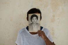 Ngesti Puji “Yayuk” Rahayu in 2012 holds her own portrait before the Bali bombing. JP/ Anggara Mahendra
