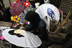 A student from the Indonesia Art and Design Academy in Surakarta makes an umbrella as a medium to convey a message. JP / Kus Hendratmo