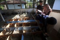 Volunteers count the number of successfully hatched eggs at the incubation center. Eggs are collected from the beach and hatched at the facility to protect them from predators. JP/ Sigit Pamungkas
