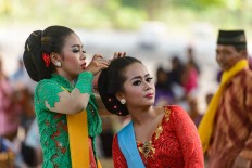 A tayub dancer helps a fellow dancer do her hair. JP/ Tarko Sudiarno