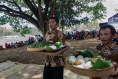 Two villagers carry offerings before the ritual.  JP/ Tarko Sudiarno