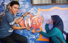 Brawijaya university students Aldi and Dwi Setyawati enjoy a moment with the famous cartoon fish. JP/ Suherdjoko