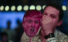 A man laughs as he holds a defaced Donald Trump mask during the election night party at a bar in Buenos Aires, Argentina, Tuesday, Nov. 8, 2016.The United States headed for the polls to vote for their new president. AP Photo/Natacha Pisarenko