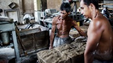 Two workers carry the dough to be made into noodles. JP/ Agung Parameswara