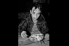 Bruised but not downfallen, Suproyadi, 19, eats his bowl of nasi soto. JP/ Aman Rochman 

