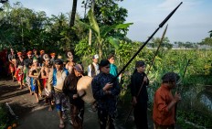 Three men carry the village heirlooms, three spears, during their tour around Tutup Ngisor village in Central Java as part of their Suro ritual. JP/Tarko Sudiarno
