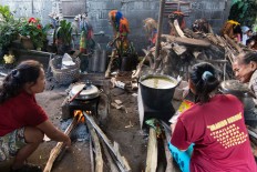 Women cook in the communal kitchen while the costumed villagers parade around the village in Central Java during the Suro ritual. JP/Tarko Sudiarno