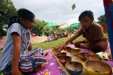 Two girls play mancala using coconut shells during the ninth Children’s Gamelan Parade in Yogyakarta.  JP/ Aditya Sagita