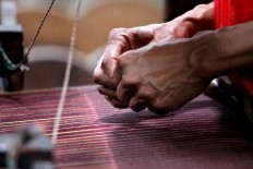 A worker prepares the yarn for weaving. JP/Aditya Sagita