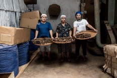 Three workers pose for a picture in the Rizona Baru cigar factory in Temanggung, Central Java. Temanggung is known as a tobacco producing regency in Indonesia. JP/Agung Parameswara
