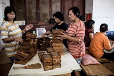 Workers put cigars into boxes at the Rizona Baru factory in Temanggung, Central Java. JP/Agung Parameswara