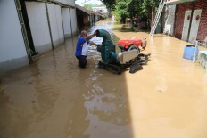 A resident prepares a portable pump to ease the deluge in Pucangsawit subdistrict in Surakarta, Central Java. JP/ Ganug Nugroho Adi