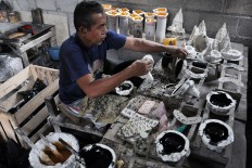 A man pours resin into a mold to make miniature Prambanan temples.JP/Magnus Kushendratmo