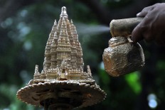 A worker sprays a figurine with gold paint. JP/Magnus Kushendratmo