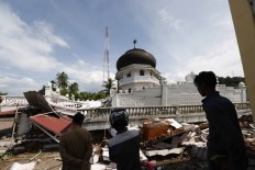 Residents observe a damaged mosque in Pidie Jaya, Aceh. An earthquake that measured 6.5 on the Richter scale hit several regencies in Aceh on Dec. 7 at 5:03 a.m. local time. At least 94 people were killed because of the quake. JP/ Hotli Simanjuntak
