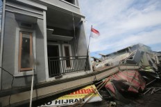 A national red-and-white flag flies over a collapsed building at Meureudu Market in Pidie Jaya regency, Aceh. JP/ Dhoni Setiawan