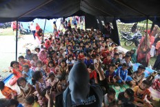 A counselor from the Social Affairs Ministry cheers up children at an evacuation camp in Meunasah Jurong village, Pidie Jaya regency, Aceh on Saturday, 10 December 2016. JP/ Dhoni Setiawan