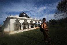 An elementary student passes by a mosque to go to his school in Pidie Jaya regency, Aceh, on Saturday, 10 December 2016. JP/ Dhoni Setiawan
