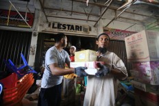Locals lend a hand to help a storekeeper remove goods from his damaged kiosk at Meureudu Market in Pidie Jaya regency, Aceh, on Saturday, 10 December 2016 JP/ Dhoni Setiawan