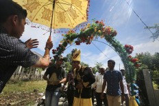 Zulkarnaen (center) and his family members arrive at the house of his bride-to-be in Meunasah Jurong village, Pidie Jaya regency, Aceh. The groom wears the traditional wedding attire of Aceh. JP/ Dhoni Setiawan
