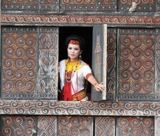 Opening up: A Torajan woman poses from inside a Tongkonan traditional house in Suloara&rsquo; village. JP/ PJ Leo