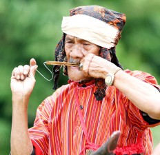 Home music: Pelipus Randan plays a traditional karombi instrument made out of bamboo and played by pulling a thread placed on its tip. JP/ PJ Leo

