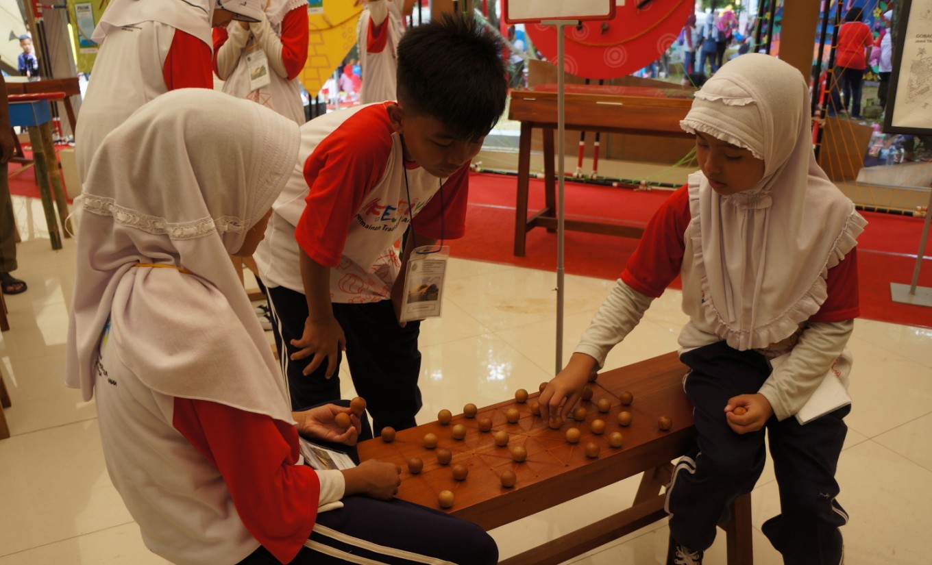 Children play "dam-daman" at the traditional toys exhibition at the Traditional Indonesian Children's Toys Festival 2016 at Taman Bhineka Tunggal Ika, Taman Mini Indonesia Indah, East Jakarta, on Dec. 11.