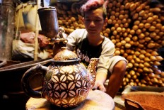 After the coloring process, artisans still have to cover their pottery with melamine or aqualaquer so that their colors can be glossier and last longer. warna JP/Ganug Nugroho Adi

 