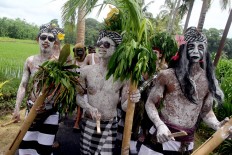 Participants paint their faces to create fearsome expressions during the Ngedeblag ritual in Gianyar, Bali. JP/ Zul Trio Anggono