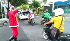 A traffic control volunteer dressed as Santa Claus directs traffic at Jl. Wora Wari, Surakarta, Central Java. He wears the unique costume to celebrate Christmas day. JP/Ganug Nugroho Adi