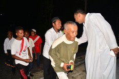 Rev. Hieronimus Jelahu [right], a Catholic priest of Santo Arnoldus and Yoseph Waelengga Church, Ruteng, Flores East Nusa Tenggara, greets young people from the Baturrahman Waelengga Mosque after the Christmas Eve mass on Saturday night. The youth of Baturrahman Mosque were involved in securing the area around the church during Christmas mass.JP/Markus Makur