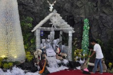 A churchgoer at Johannes the Apostle church, Wonogiri, Central Java, cleans the nativity scene made from over 3,000 used mineral water bottles on Dec. 24. JP/Magnus Hendratmo. 