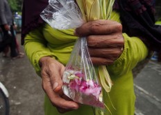 A Surakarta resident carries a plastic bag containing water and flower petals as an offering in a ritual called Miyos Gongso. JP/Ganug Nugroho Adi
