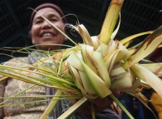 A Surakarta resident holds young coconut leaves successfully snatched from a gunungan [cone shaped offerings] during Sekaten. JP/Ganug Nugroho Adi