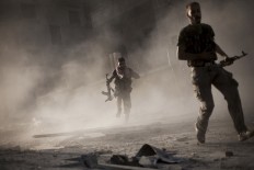 Free Syrian Army fighters run away after attacking a Syrian Army tank during fighting in the Izaa district in Aleppo, Syria, Friday, Sept. 7, 2012.