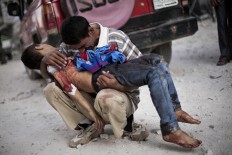 A man cries while holding the body of his son, killed by the Syrian Army, near Dar El Shifa hospital in Aleppo, Syria, Oct. 3, 2012. 