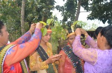 Passing the tradition: Ndolu women put paddy on the heads of Ndolu girls to perform the Karong Woja Wole tradition. JP/Markus Makur