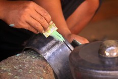 Workers fill in the cracks and gaps in the welding with some putty. JP/Aditya Sagita