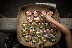 Living in harmony: Gung Dewi makes Balinese offerings on a woven bamboo basket. JP/ Agung Parameswara