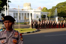 Policemen stand guard during the 10th commemoration of the Kamisan silent protest in front of the Presidential Palace in Jakarta on Jan. 19. The 477th Kamisan marks the 10th year since the first protest in 2007 asking the government to resolve past human rights violations. JP/Seto Wardhana.